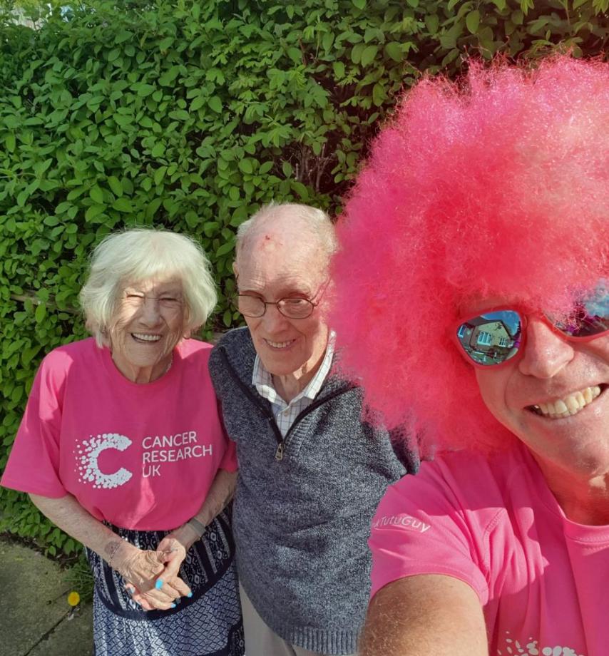 Margaret and Ron smiling in the sunshine with David in full pink